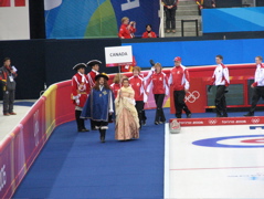 The curling teams being led out by folks from the local theatre company